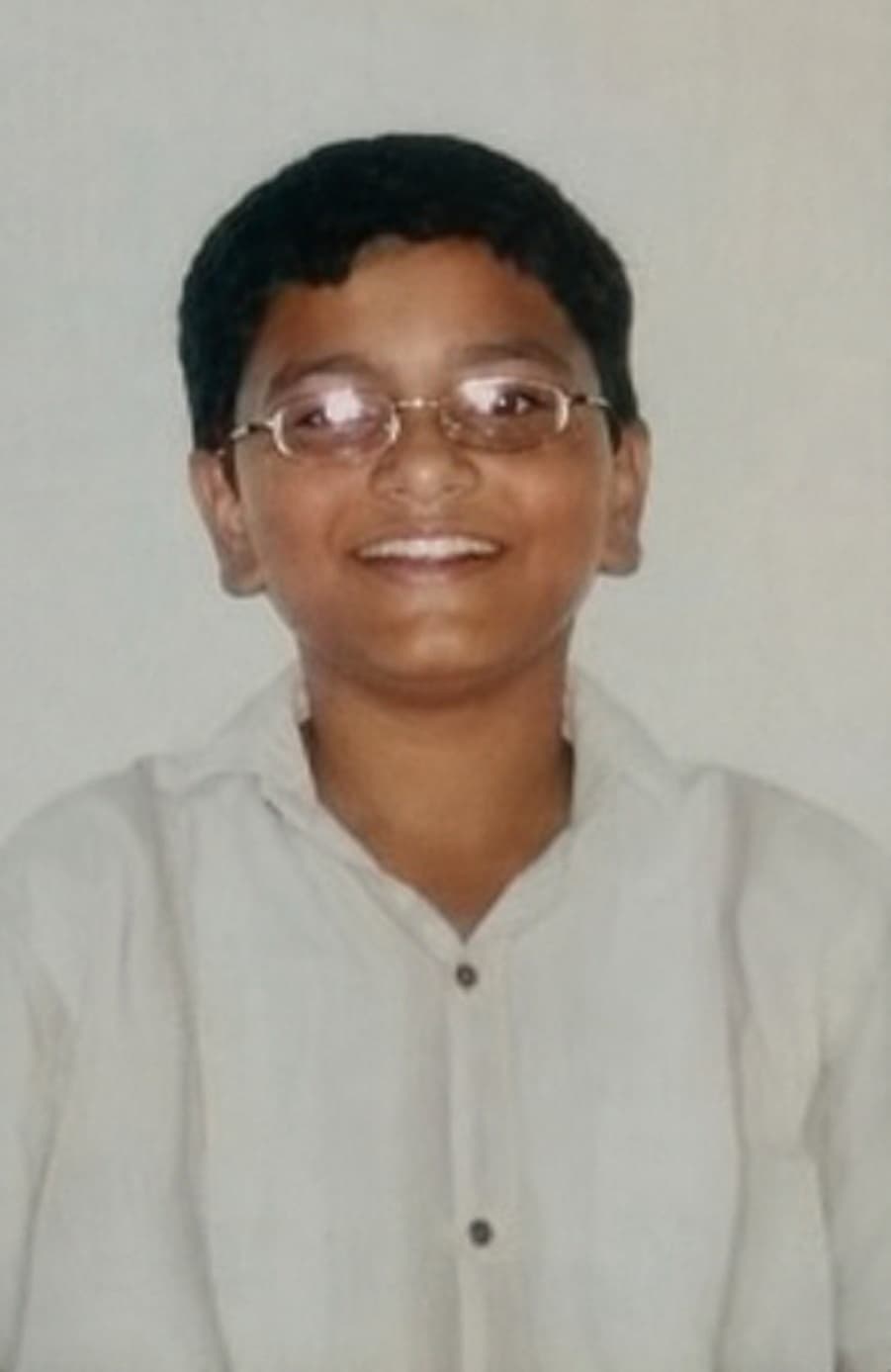 Asad as a child wearing glasses and a white shirt