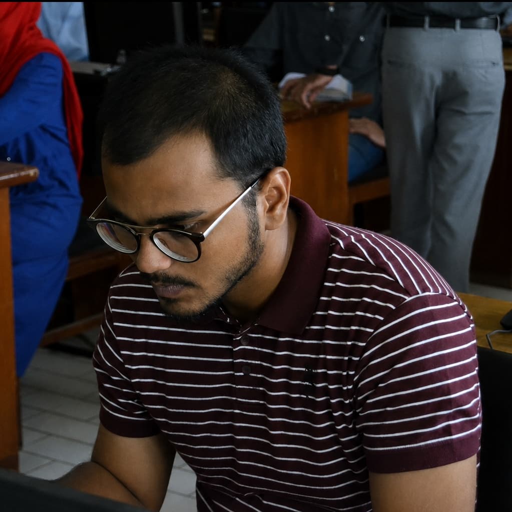 Asad studying at a table during his university years