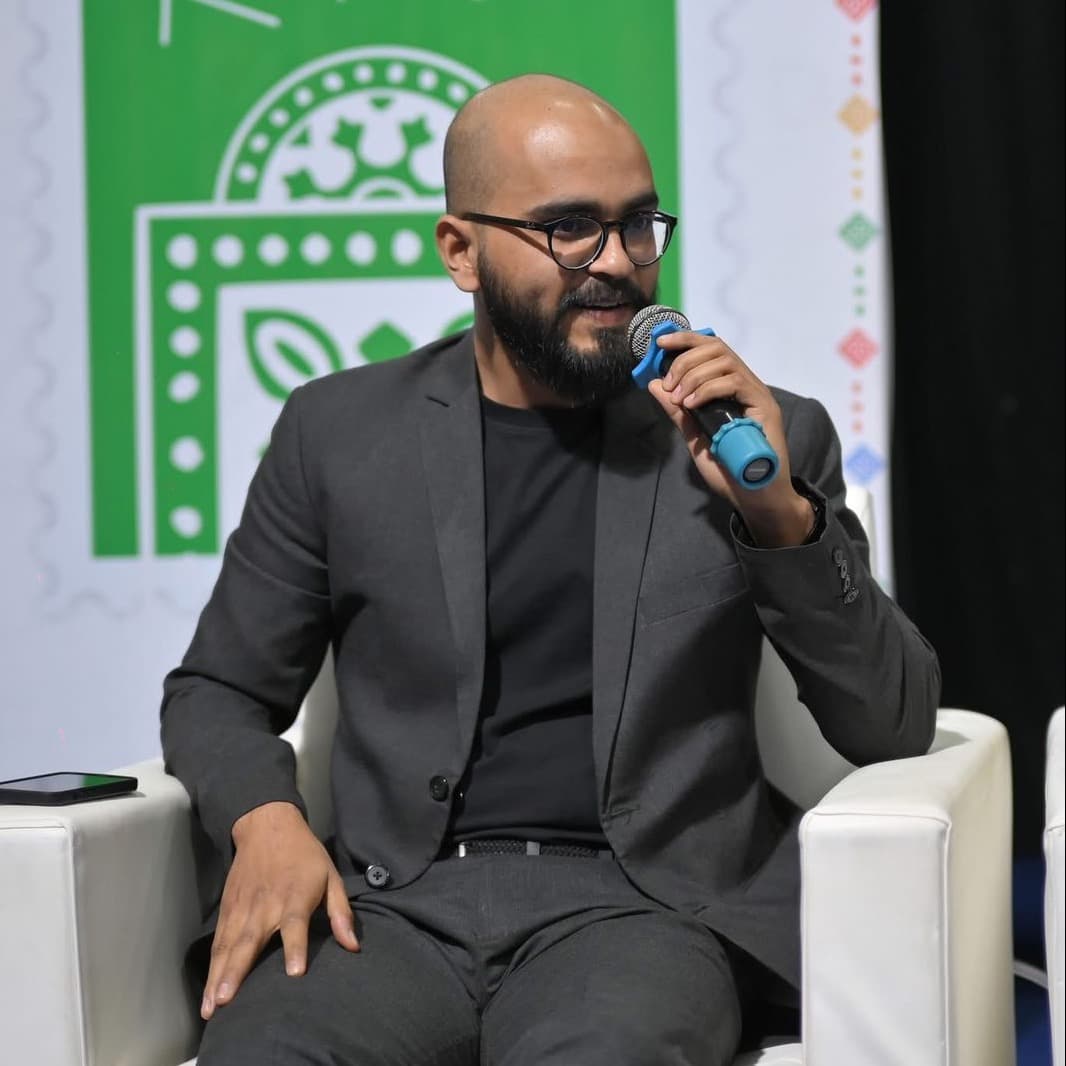 Asad speaking into a microphone at a public event